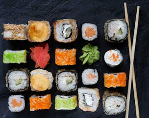 Set of sushi and maki on stone table.