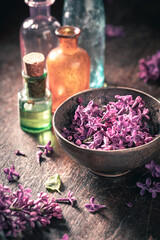 Fototapeta na wymiar Special glass with flower lilac oil. Lilac aromatic oils.