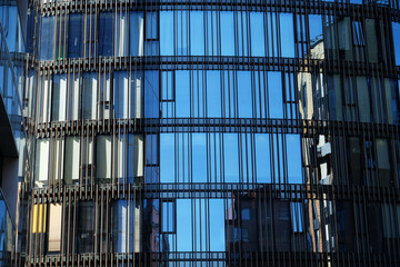 Offices building exterior in summer sunny day. Blue sky had been reflected in the glass of windows.