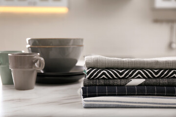 Stack of soft kitchen towels on white table indoors, space for text