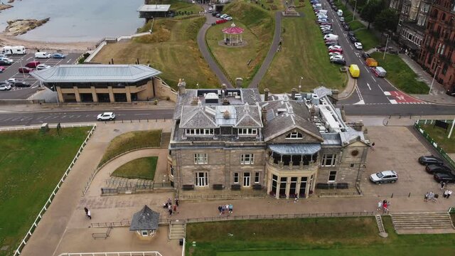 Low-level aerial footage of the Royal and Ancient Club house in the historic town of St. Andrews, Fife, Scotland. With the World Golf Museum and bandstand in the background.