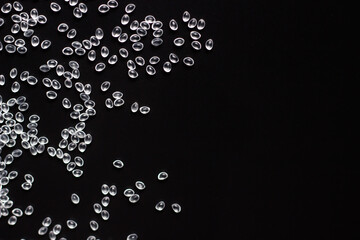 white granules of rubber and polypropylene on a black background. Plastics and polymers industry. Copy space