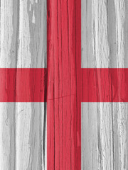 The flag of England on a dry wooden surface, cracked with age. It seems to flutter in the wind....