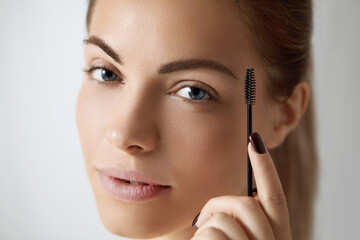 Obraz premium Young beautiful woman correcting shape of eyebrows. Contouring Eyebrow makeup .