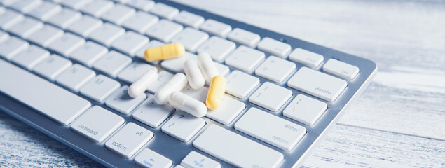 pills on white keyboard on table