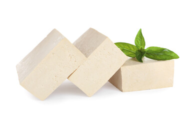 Blocks of delicious raw tofu with basil on white background