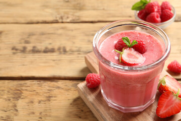 Delicious berry mousse with mint on wooden table, space for text