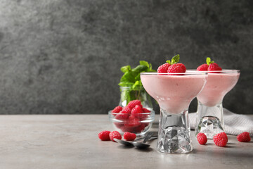 Delicious raspberry mousse with mint on light grey table, space for text