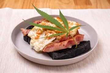 Homemade breakfast with marijuana or cannabis leaf on white plate.