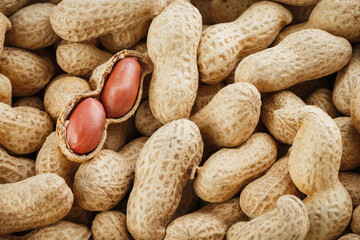 Peanut fruit peeled against the background of unpeeled peanuts.