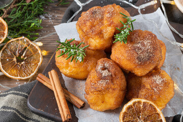 Traditional portuguese Christmas sweets Sonhos with sugar and cinnamon on kitchen countertop.
