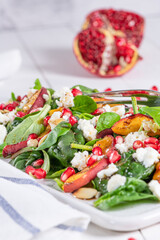 Salad. Spring vegetable salad. Fresh vegetable salad with grilled peach, pomegranate, spinach and fresh cheese.