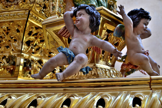 Small sculptures of baby angels from a golden Easter step