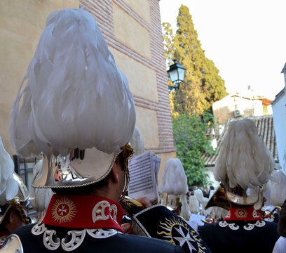Music band of the Aurora de Granada procession with a feathered helmet in the foreground