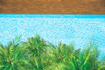 Fototapeta na wymiar Aerial drone view from above on swimming pool and palm trees. Tropical summer luxury hotel
