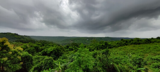 Green nature view under dark rain cloud sky