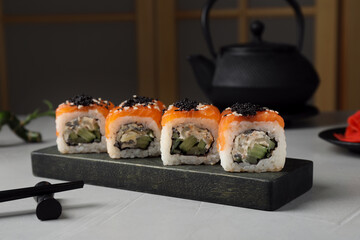 Delicious sushi rolls served on light grey table
