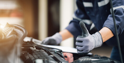 Mechanic works on the engine of the car in the garage. Repair service. Concept of car inspection...