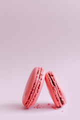Dessert of pink macaroons stands on a single background.
