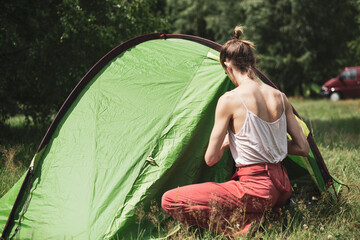 Healthy natural queer person zipping up a tent at festival in Poland