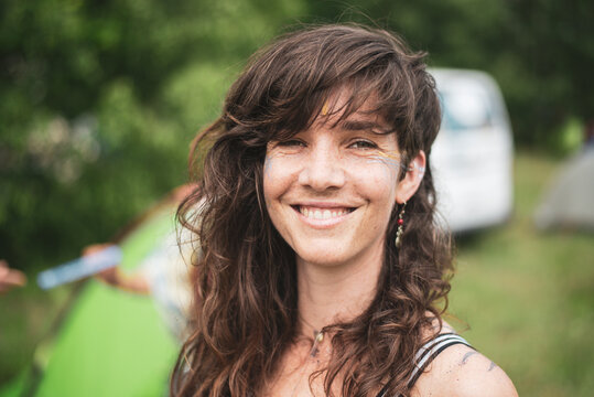 Smiling beautiful brown curly hair woman camping at festival in Poland