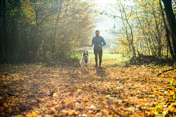 Fototapeta premium happy dog and man playing in autumn forest