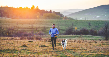 happy dog and man running in autumn field