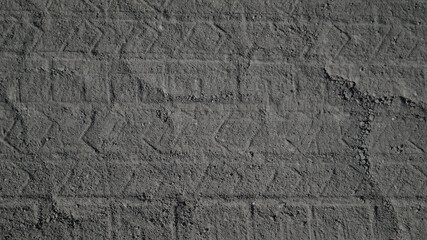 Car prints on a dirty dusty offroad. Gray background with vehicle tire track prints. Top view of tread mark on the road. 