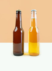 A bottles of craft lager and porter beer on dual color beige background. International beer day or Octoberfest concepts. Minimalistic colors on a photo. Front view
