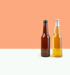 A bottles of craft lager and porter beer on dual color beige background. International beer day or Octoberfest concepts. Minimalistic colors on a photo. Front view. Copy space. Horisontal
