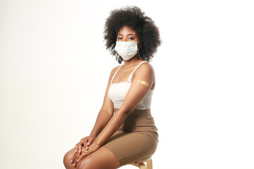 beautiful african woman in medical mask after vaccine injection 