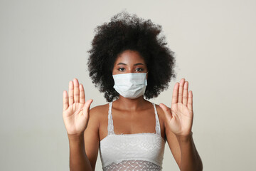 portrait of african woman in medical mask on white background with hand gesture 