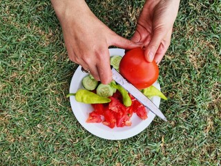 Woman making salad at picnic.