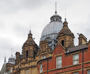 Fototapeta na wymiar ornate stone towers and domes on the roof of leeds city market a historical building in west yorkshire england