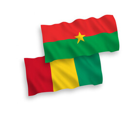 National vector fabric wave flags of Burkina Faso and Guinea isolated on white background. 1 to 2 proportion.