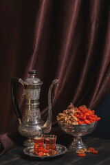 Ancient East metallic crockery - vintage jug, vase with dried fruit and plate with tea in armuda glasses