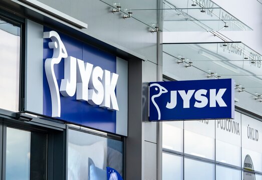 The banners of Jysk company above the entrance to the shop where houseware is sold