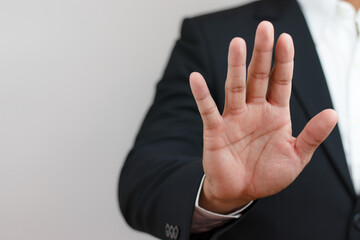 businessman raising his hand in front indicating order to stop, forbid, invalid. Corruption,...