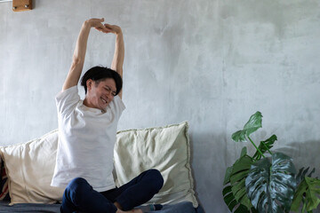 ベッドで伸びをする若い男性