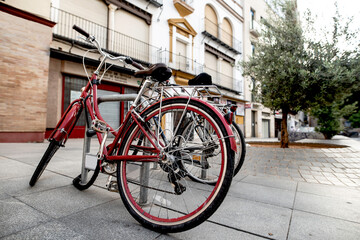Fototapeta na wymiar Bicicleta roja aparcada en el centro de la ciudad en Sevilla Andalucía España