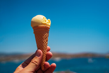 ice cream cone on the beach. Ice cream in a waffle cup against the background of the sea and the...
