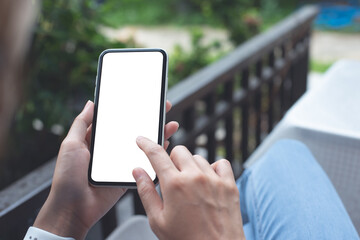 Cell phone mockup image blank white screen.  Woman hand holding, using mobile phone at home.