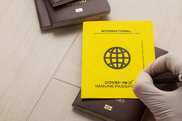 Hand signing vaccine passports as proof that the holder has been vaccinated against Covid-19,...