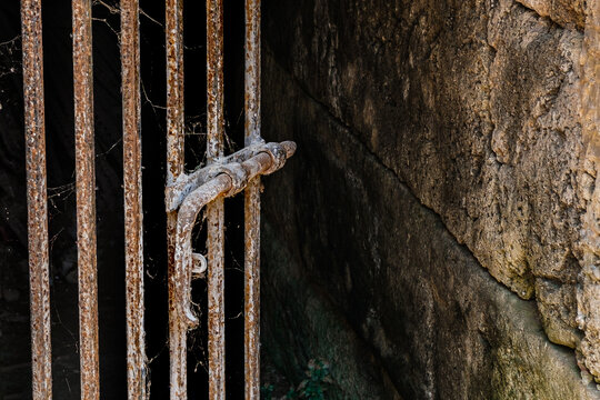 Old metal open door in stone brick wall, rusty lock
