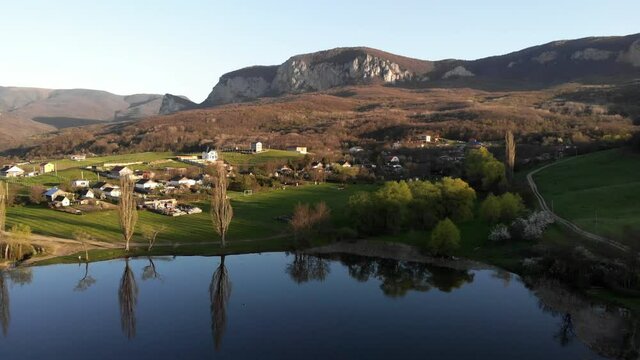 Nice little village in the mountains next to the lake. Beautiful bird's-eye view. Incredible nature. Life in the countryside.