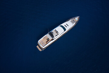 A huge white super Mega yacht on blue water in Italy. White yacht open sea aerial view. Super yacht on blue water top view.