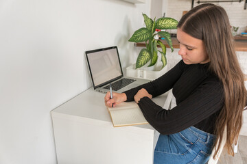 girl writing in a notebook while working