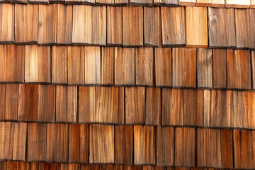Brown and weathered wood shingles on a wall. Wooden background