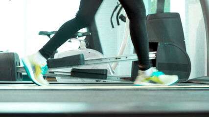Close up Foot Fitness Asian woman walk warm up and running on treadmill by side view camera, marathon races training at fitness gym