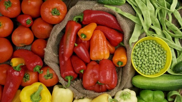 Set of different fresh raw vegetables in the wooden tray, wood background, top view